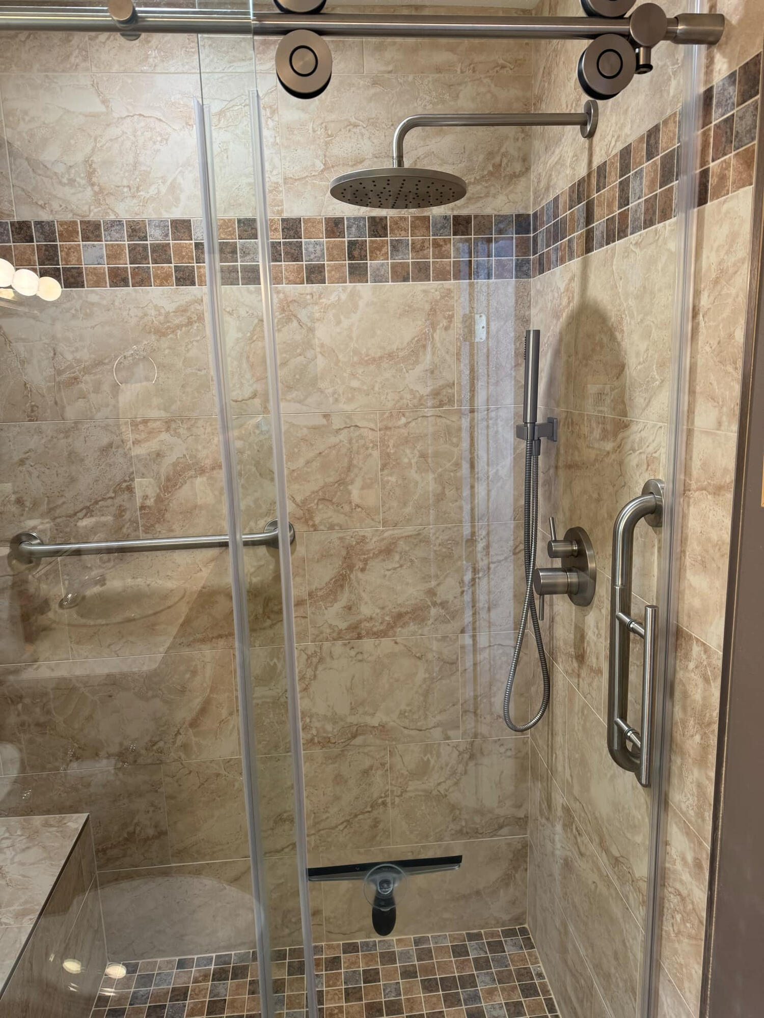 Tiled walk-in shower with glass door